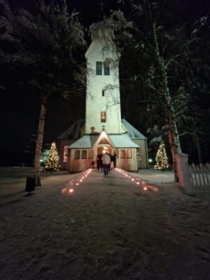 Arjeplogs kyrka med tända ljust utanför